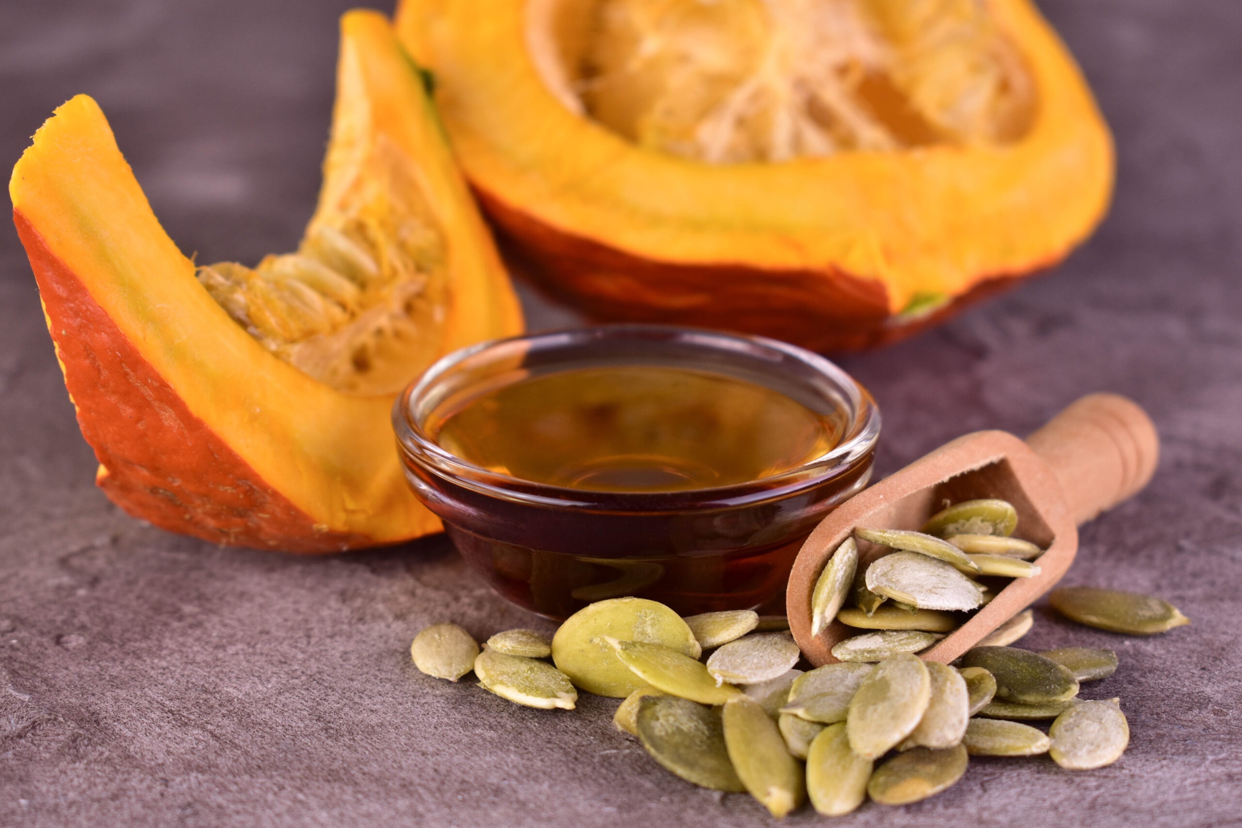 Bol d'huile de péppins de courges, graines de courges et courge tranchée