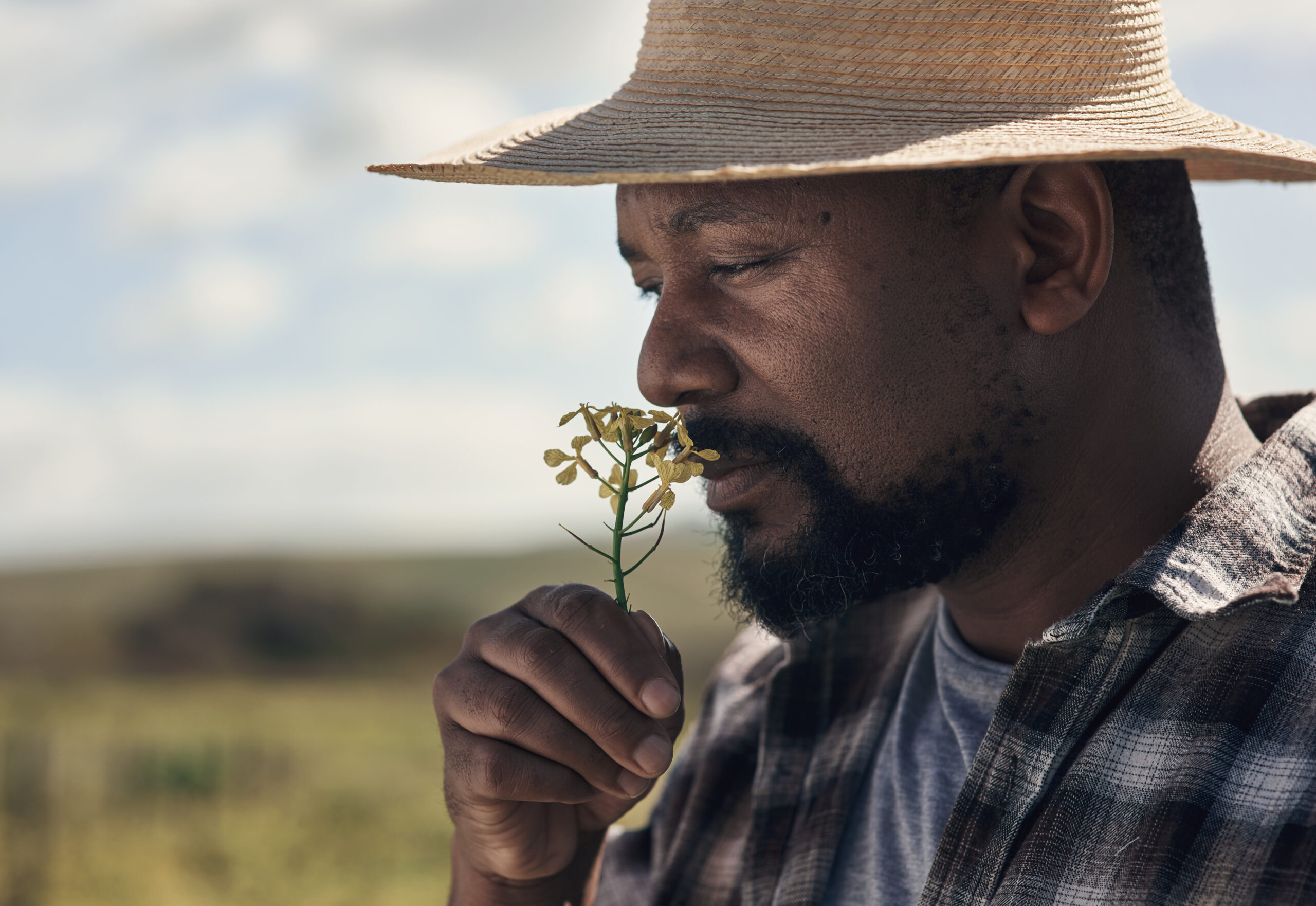 Sourcing éthique illustré par le protrait photo d'un homme avec une fleur dont il respire le parfum