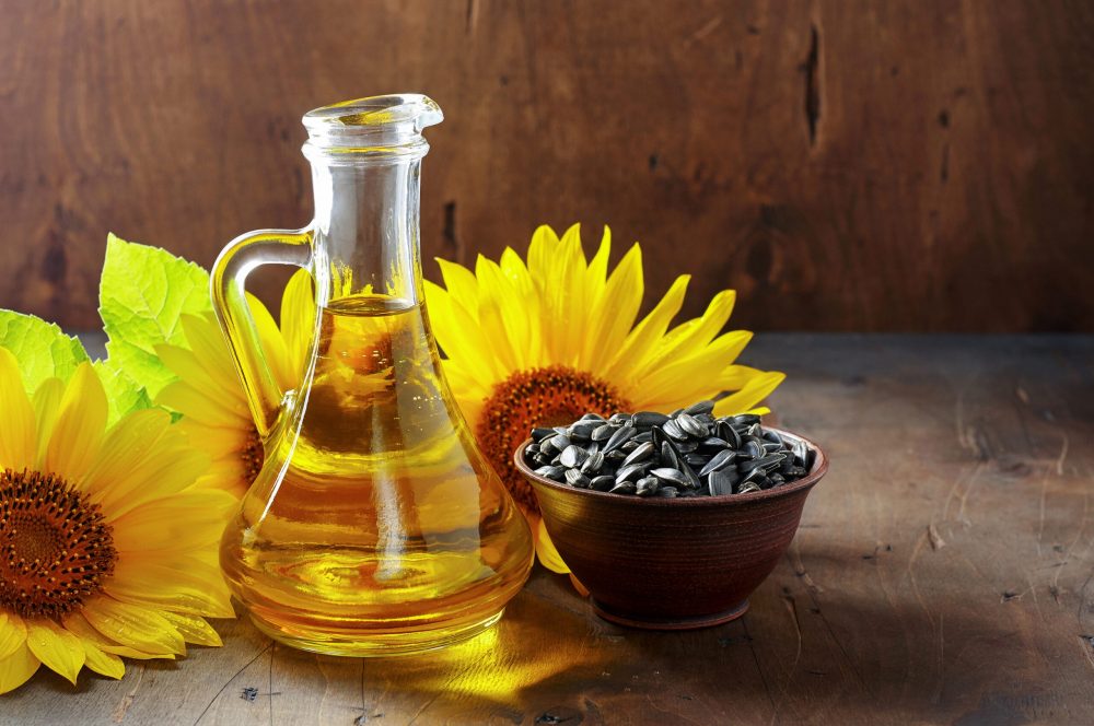 Petit bol contenant des graines de tournesol avec des fleurs de tournesol autour