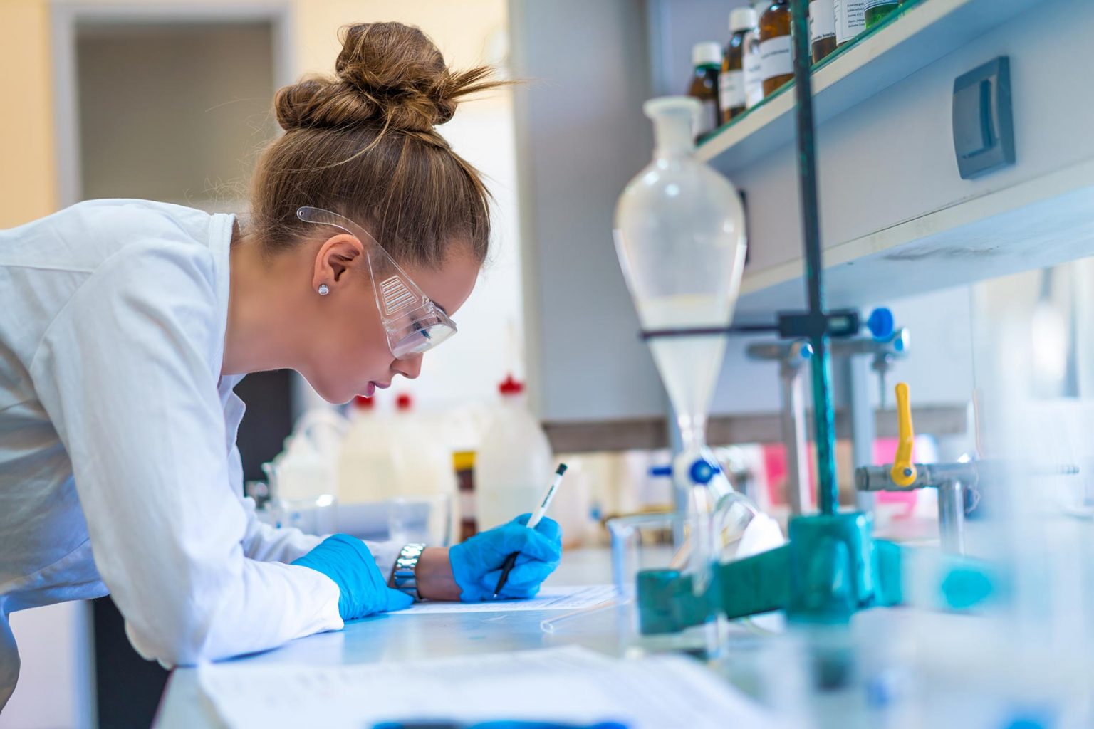 Beautiful young woman scientist in laboratory working.